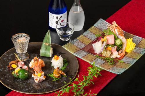 a table with two plates of food on it at Hanabishi Hotel in Hakodate