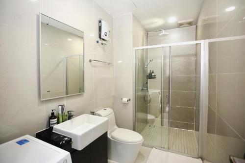 une salle de bains avec douche, toilettes et lavabo dans l'établissement Kid-Loving Poolside Haven - 2BR - Netflix - Games, à Johor Bahru