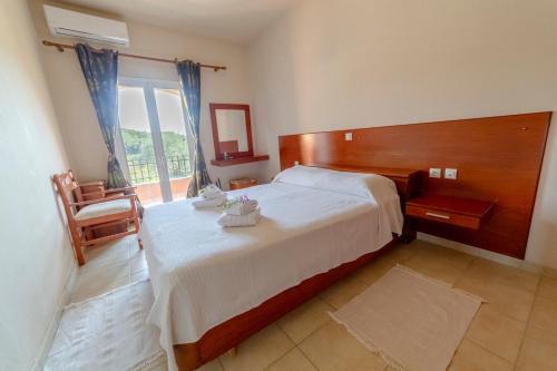 a bedroom with a large bed and a large window at Markatis House with views to Corfu east in Káto Spílaion