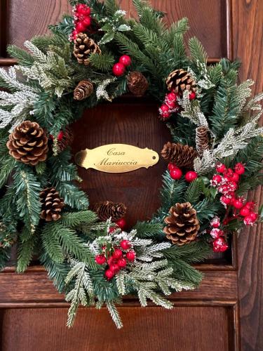 a christmas wreath on a wooden door at Casa Mariuccia in Anzio