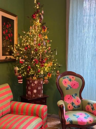a living room with a christmas tree and two chairs at Casa Mariuccia in Anzio