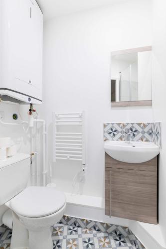 une salle de bain blanche avec des toilettes et un lavabo dans l'établissement Studio neuf Metro Jaures- Paris 19 - 2P - FLAT-GUEST, à Paris