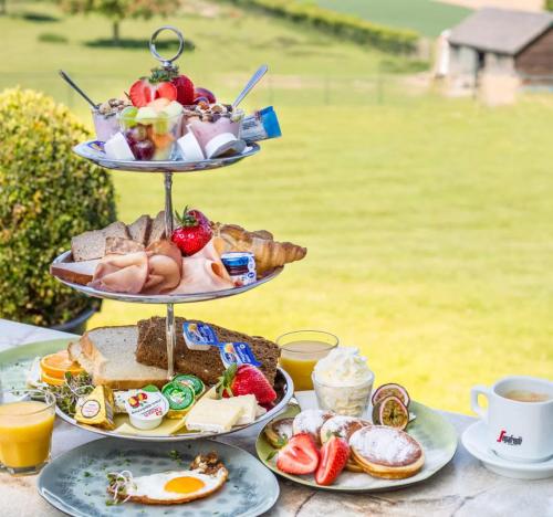 a three tiered tray of breakfast food on a table at Valley view cottage vlakbij Valkenburg in Voerendaal
