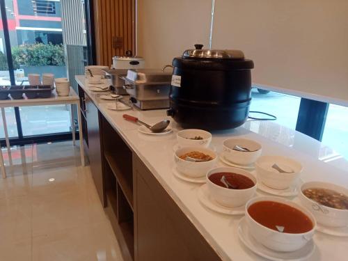a kitchen with bowls of food on a counter at PT Grand Hotel in Ban Tha Makham