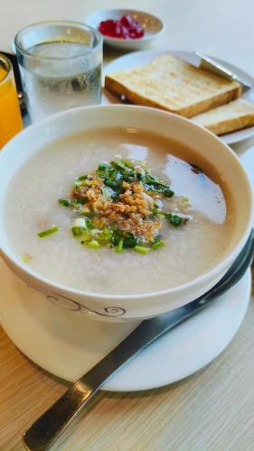 a bowl of soup sitting on a table with a knife at PT Grand Hotel in Ban Tha Makham