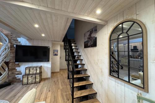 - un escalier en colimaçon dans une maison avec une télévision murale dans l'établissement Attractive 3-rooms cottage with terrace, à Cabourg