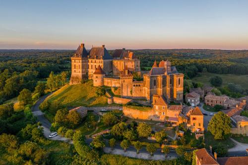 une vue aérienne d'un château sur une colline dans l'établissement Huttopia Vallée du Lot, à Saint-Étienne-de-Villeréal