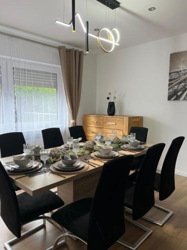 a dining room table with black chairs and a dining room at Ferienwohnung Mobembo in Konz