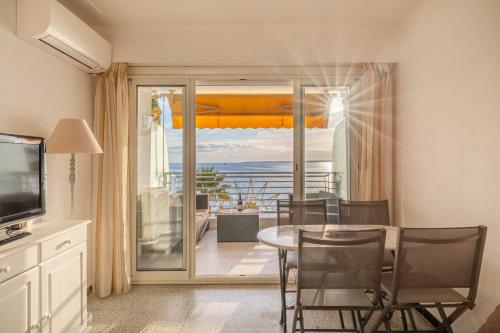 une salle à manger avec une table et une vue sur l'océan dans l'établissement Le Soleil Front de Mer Centre Juan Les Pins, à Antibes
