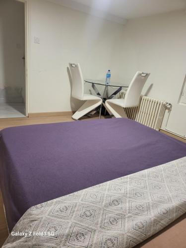 une chambre avec un lit, des chaises et une table dans l'établissement Chambre privée chez l'habitant, à Longvic