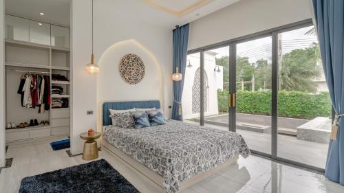 a bedroom with a bed and a large window at Bang Tao Villa - Menara Hill in Phuket Town