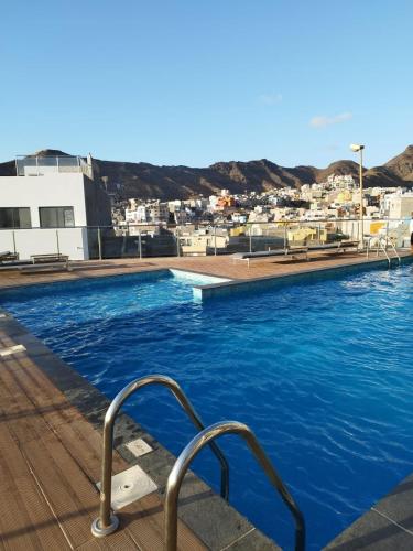 una piscina con acqua blu e una città sullo sfondo di Mindelo Sunset a Mindelo