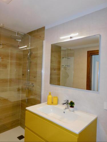 a bathroom with a sink and a shower with a mirror at b&b Tati in Sedico