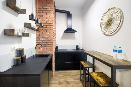 a kitchen with black counters and a brick wall at AboutArtApartments - By the river in Wrocław