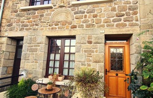 a stone building with a wooden door and windows at Gîte des Forges, au cœur d'une cité médiévale in Moncontour