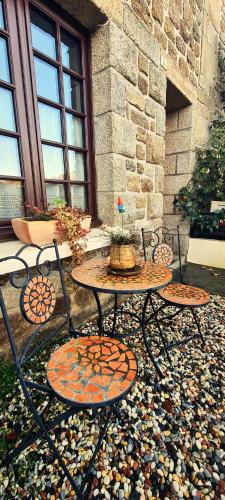 two tables and chairs sitting in front of a building at Gîte des Forges, au cœur d'une cité médiévale in Moncontour