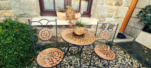 a patio with a table and chairs and a table with a plant at Gîte des Forges, au cœur d'une cité médiévale in Moncontour