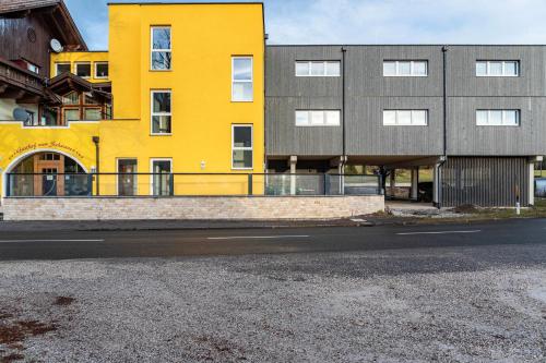 a yellow and gray building on the side of a street at Hotel zum Schwanen - Appartement 6 in Pflach