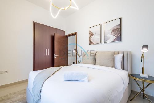 a bedroom with a large white bed and a table at Elegant 4BR Villa with Assistant Room in Al Dana Island, Sharm, Fujairah by Deluxe Holiday Homes in Fujairah