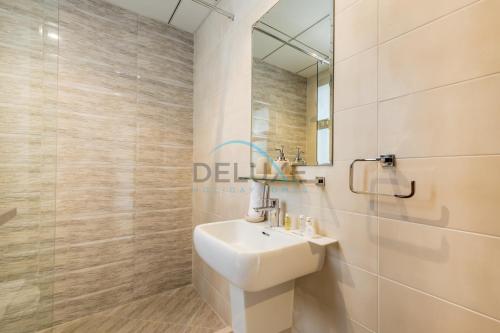 a bathroom with a sink and a mirror at Elegant 4BR Villa with Assistant Room in Al Dana Island, Sharm, Fujairah by Deluxe Holiday Homes in Fujairah