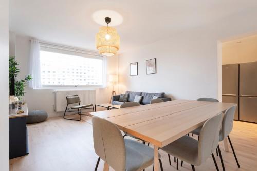 Il dispose d'une cuisine et d'un salon avec une table et des chaises en bois. dans l'établissement La Résidence du Général, à Nancy