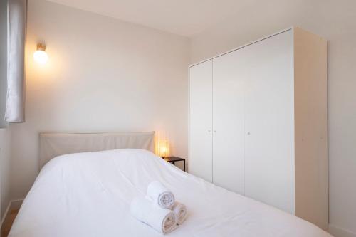 une chambre avec un lit blanc avec des serviettes dessus dans l'établissement La Résidence du Général, à Nancy