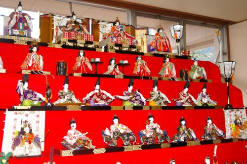 a display of chinese figurines on a red shelf at Bosenkan in Gero