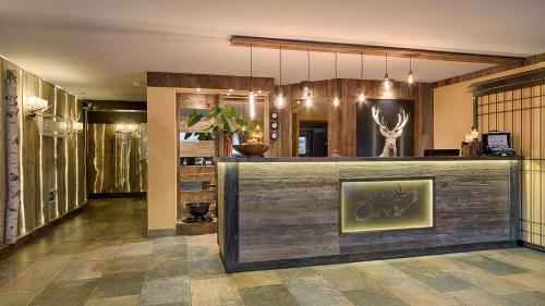 a lobby with a bar with a painting on it at Hotel Cervo in Sils Maria