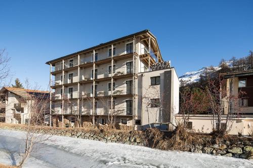 a building on the side of a snowy road at Hotel Cervo in Sils Maria