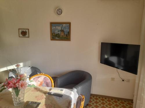 a living room with a couch and a tv on the wall at Friendly Philoxenia in Xanthi