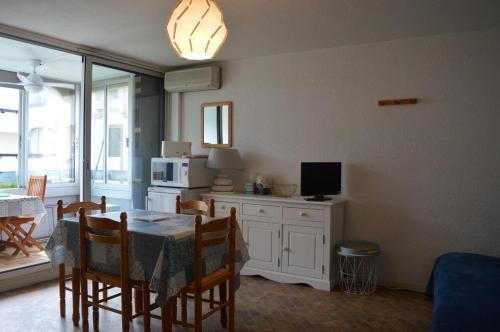 une salle à manger avec une table, des chaises et une télévision dans l'établissement Appartement 2 pièces 4 couchages ST CYPRIEN PLAGE SC510-14D1, à Saint Cyprien Plage