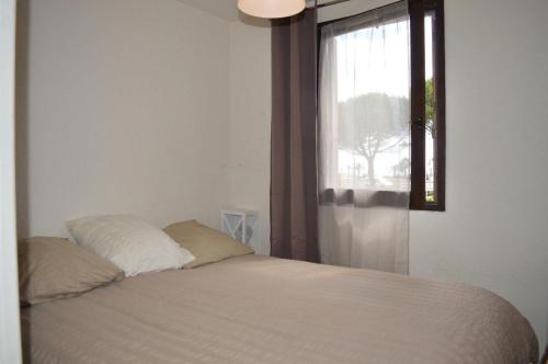 - un lit avec deux oreillers dans une chambre dotée d'une fenêtre dans l'établissement Appartement 2 pièces 4 couchages ST CYPRIEN PLAGE SC510-14D1, à Saint Cyprien Plage