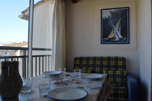 - une table avec des plaques et un bateau sur la fenêtre dans l'établissement 2 Pièces ST CYPRIEN SC020-114, à Saint Cyprien Plage