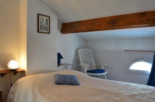 une chambre avec un lit, une fenêtre et une chaise dans l'établissement 2 Pièces ST CYPRIEN SC020-114, à Saint Cyprien Plage