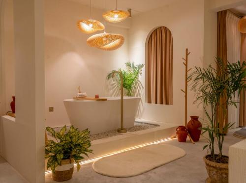 Un baño con bañera con plantas y luces. en Lagom Premium Apartment, en Katmandú