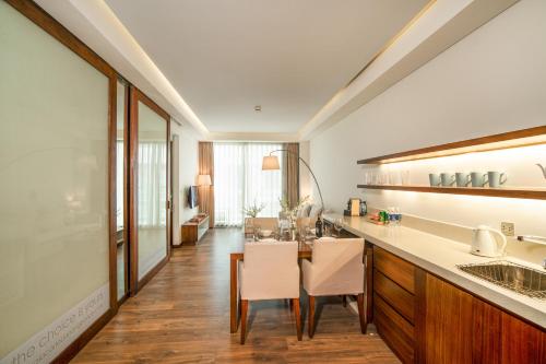 a kitchen with a table and a dining room at Premium Apartment, Balcony Ocean View,Infinity Pool, 01 Min To My Khe Beach, PickUp Managed by Ala Carte Da Nang in Da Nang