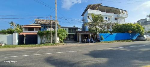 a street with a white building and a road with a house at Niro House and Restaurant in Ahangama
