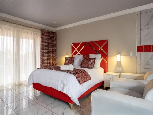 a bedroom with a large bed with a red headboard at SelaMod Village Guest House in Tshaneng