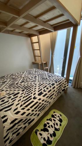a bed with a black and white comforter with pandapillars on at Beach Road Hampton Holidays in Melbourne