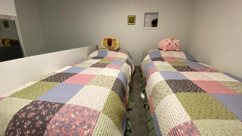 a bedroom with two twin beds with a blanket at Beach Road Hampton Holidays in Melbourne