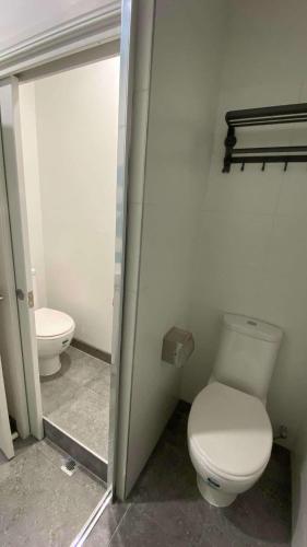 a bathroom with a toilet and a sink and a mirror at Beach Road Hampton Holidays in Melbourne