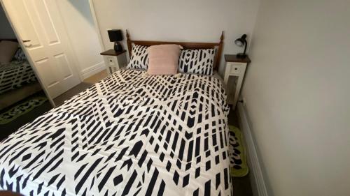 a bedroom with a bed with a black and white comforter at Beach Road Hampton Holidays in Melbourne