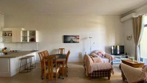 a kitchen and living room with a table and chairs at Beach Road Hampton Holidays in Melbourne