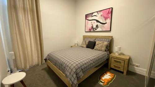 a small bedroom with a bed and a table at Beach Road Hampton Holidays in Melbourne