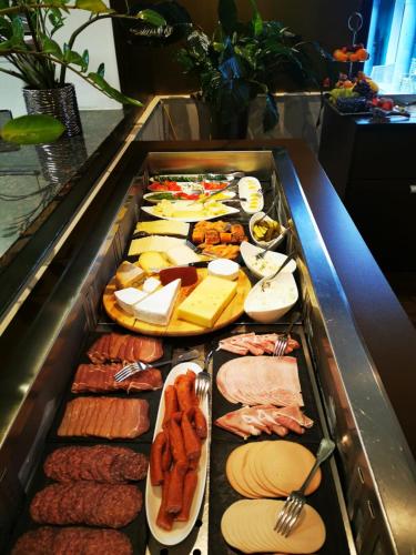 a tray filled with different types of meats and cheese at Boutiquehotel Goldhahn Bio Sport & Wellness in Aalen