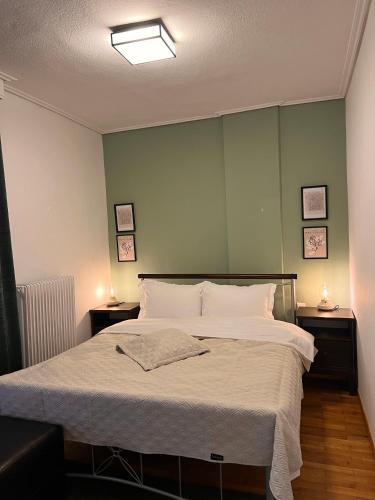 ein Schlafzimmer mit einem großen Bett und zwei Nachttischen in der Unterkunft 19 Αri in Tríkala