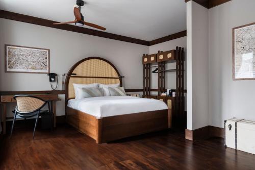 a bedroom with a bed and a desk and a ceiling fan at Numa Berlin Potsdamer Platz in Berlin