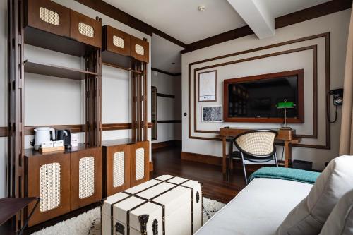 a room with a bed and a desk and a television at Numa Berlin Potsdamer Platz in Berlin