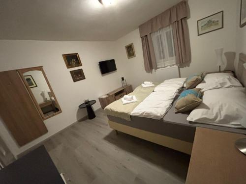 a small bedroom with a bed and a mirror at Apartments Gato Karlovy Vary Jenišov in Karlovy Vary