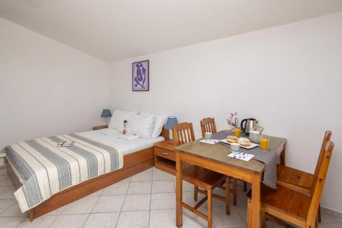 a bedroom with a bed and a table with a dining room at Apartments POLARIS in Baška Voda